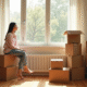 Jeune femme assise sur des cartons dans un appartement lumineux